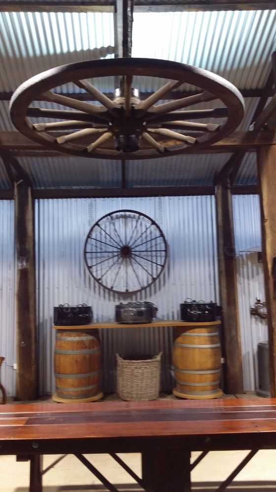 A restored wagon wheel repurposed as a hanging light fitting above the bar, with a second wheel mounted on the wall.